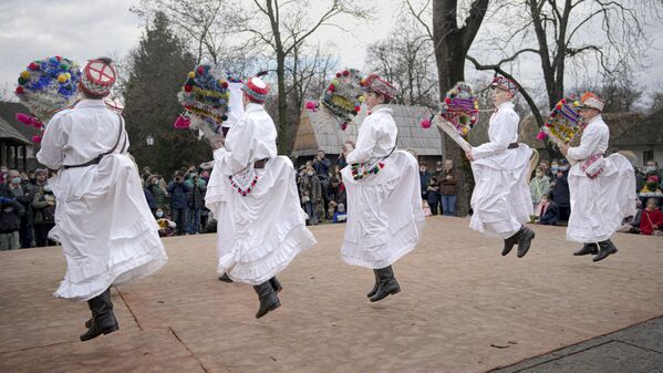Молодые люди танцуют во время шоу зимних традиций в Бухаресте, Румыния. - Sputnik Азербайджан