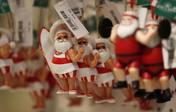 Елочные игрушки в виде Санта-Клауса в шортах в Лондоне. - Sputnik Азербайджан