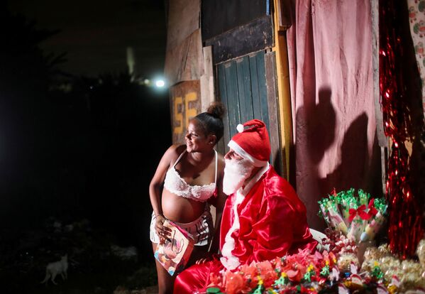 16-летняя Кэролайн Витория получает подарок от Санта-Клауса в трущобах Сидаде-де-Деус в Рио-де-Жанейро, Бразилия. - Sputnik Азербайджан