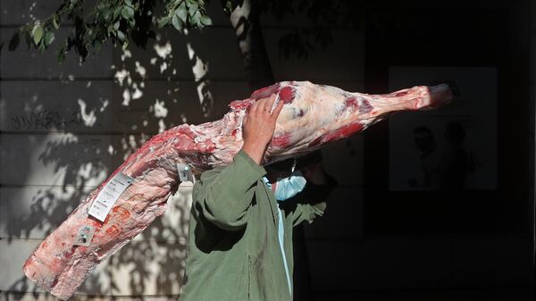 Рабочий несет кусок мяса, фото из архива - Sputnik Азербайджан