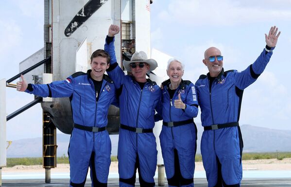 Оливер Дэмен, Джефф Безос, Уолли Фанк и Марк Безос позируют фотографу возле ракеты-носителя после полета в космос на ракете Blue Origin New Shepard, 20 июля 2021 год - Sputnik Азербайджан