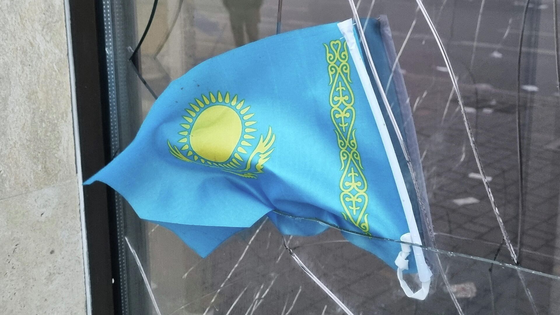 Государственный флаг Казахстана на разбитом окне банка, фото из архива - Sputnik Азербайджан, 1920, 10.01.2022