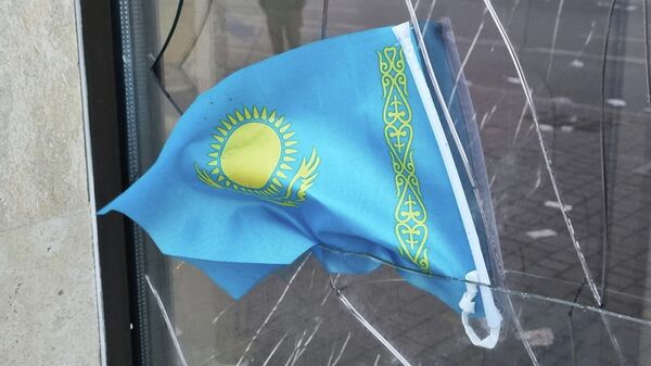 Государственный флаг Казахстана на разбитом окне банка, фото из архива - Sputnik Азербайджан