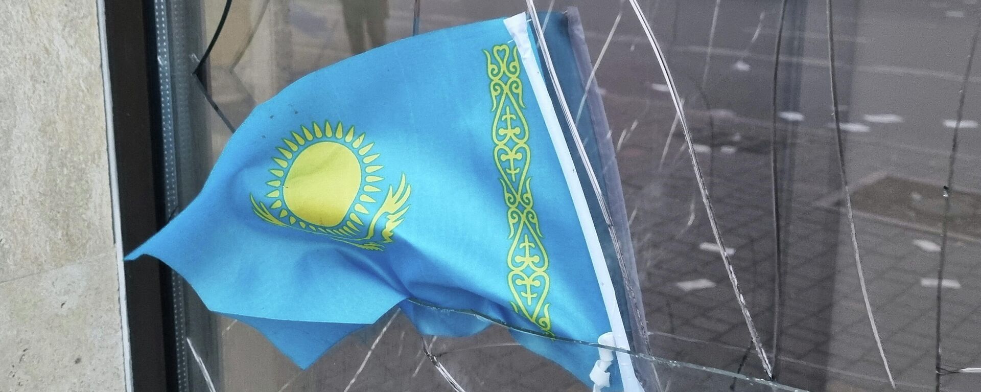 Государственный флаг Казахстана на разбитом окне банка, фото из архива - Sputnik Азербайджан, 1920, 10.01.2022