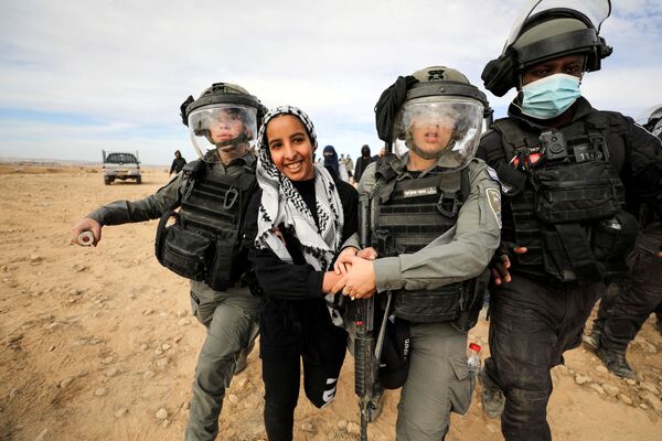 Задержание бедуинки израильскими силами безопасности во время акции протеста против вырубки лесов в деревне Саве аль-Атраш в пустыне Негев, на юге Израиля. - Sputnik Азербайджан