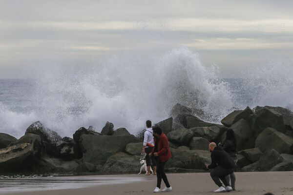 Люди наблюдают за волнами на волнорезе на Венис-Бич Лос-Анджелес, Калифорния. - Sputnik Азербайджан