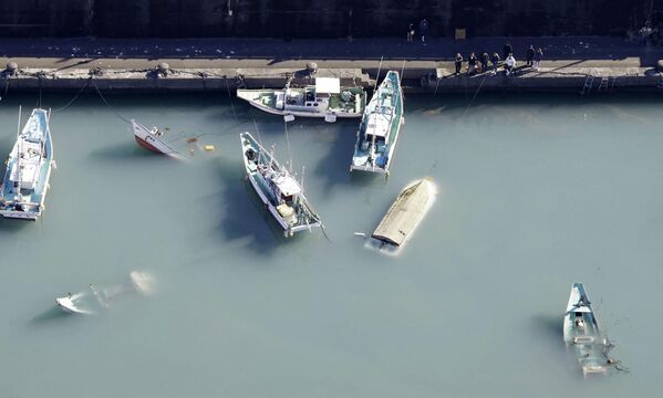 Вид с воздуха показывает перевернувшиеся лодки, предположительно пострадавшие от цунами, вызванного извержением подводного вулкана на острове Тонга. - Sputnik Азербайджан