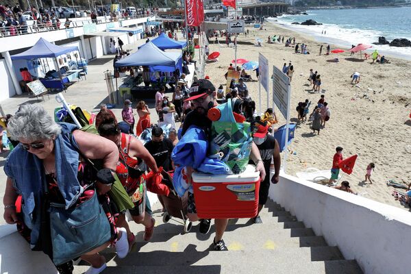 Люди эвакуируются с береговой линии в Чили после предупреждения местных властей о цунами после извержения подводного вулкана на острове Тонга. - Sputnik Азербайджан