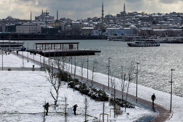 Люди гуляют на заснеженной набережной в Стамбуле. - Sputnik Азербайджан