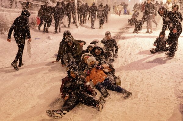 А детям снег был в радость. Они катались по снегу, кувыркались и смеялись. - Sputnik Азербайджан