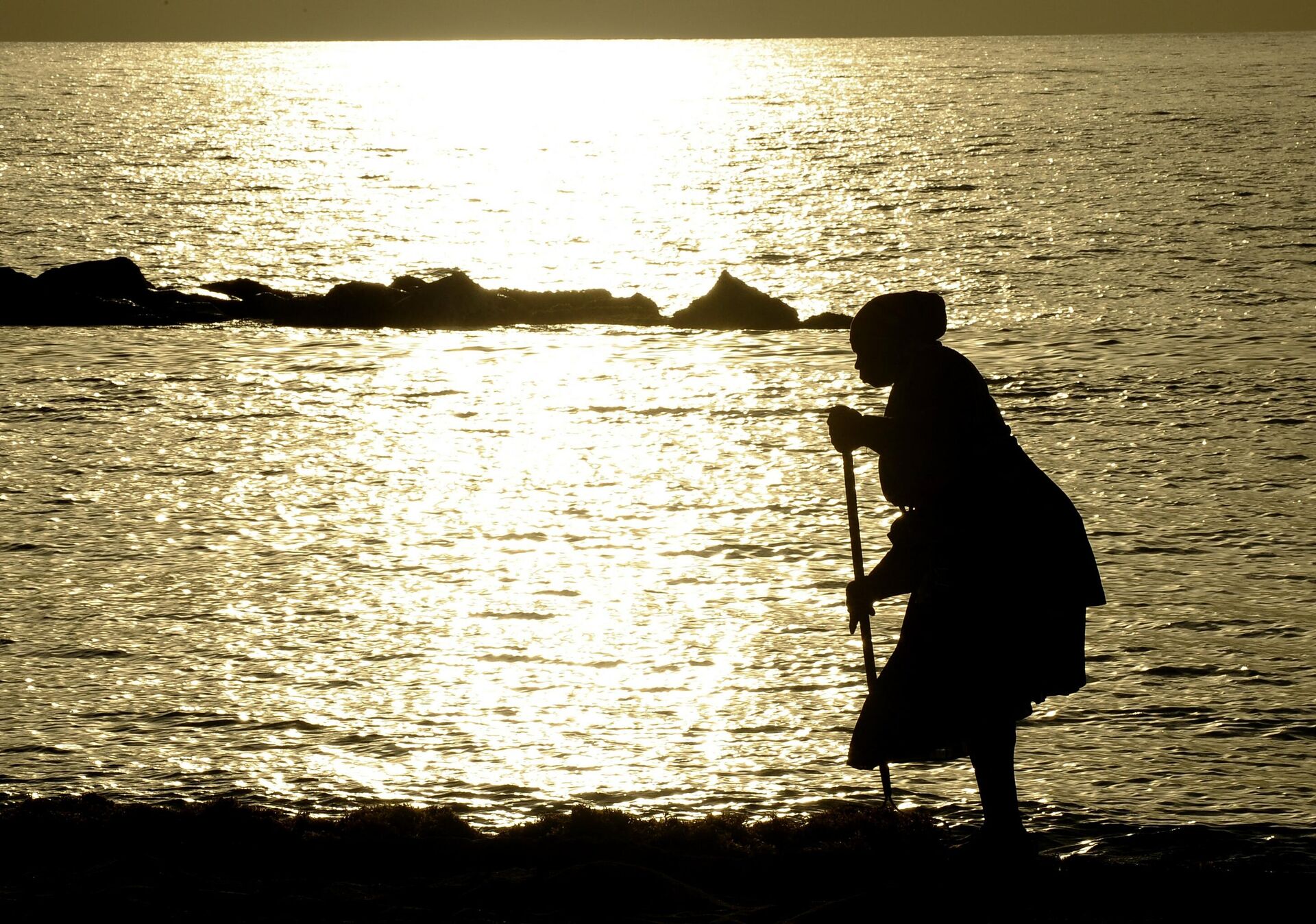 Женщина подметает песок на пляже возле курорта на берегу Атлантического океана в Бастере, столице Сент-Китс. - Sputnik Азербайджан, 1920, 25.01.2022