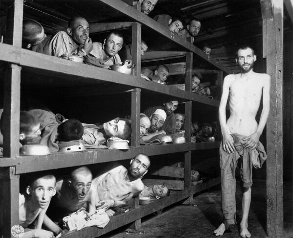 Освобождённые узники Бухенвальда, 16 апреля 1945 года. Первым лагерем, созданным именно в качестве лагеря уничтожения, был Хелмно (Кулмхоф) в Польше. Он начал действовать 8 декабря 1941 года, когда туда были свезены евреи из окрестных городов и местечек. Вначале орудием убийства в Хелмно служили грузовики-душегубки. Всего там было убито примерно 320 000 человек. - Sputnik Азербайджан