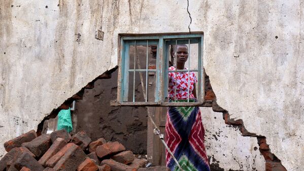 Женщина смотрит на свой дом, разрушенный тропическим штормом Ана в деревне Канджедза, Малави. - Sputnik Азербайджан