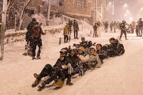 Дети катаются по снегу в районе Кучукчекмедже в Стамбуле. - Sputnik Азербайджан