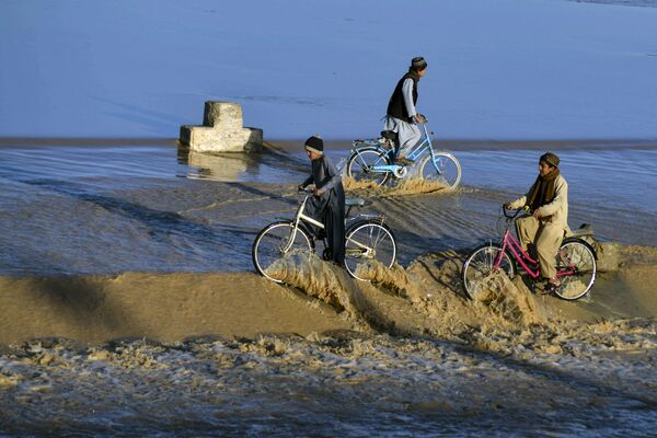 Мальчики катаются на велосипедах по паводковым водам в Кандагаре. - Sputnik Азербайджан