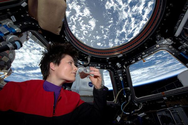 Итальянский астронавт Саманта Кристофоретти потягивает эспрессо из чашки, предназначенной для использования в условиях невесомости на Международной космической станции, 3 мая 2015 год - Sputnik Азербайджан