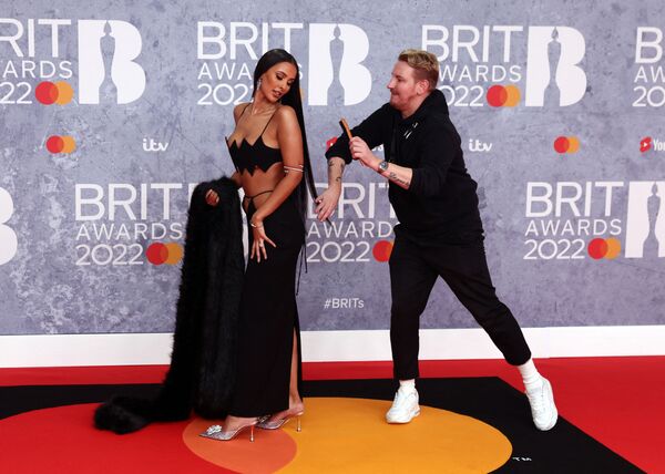 Ассистент поправляет прическу британской ведущей Майе Джэма на вручении премии Brit Awards в Лондоне. - Sputnik Азербайджан