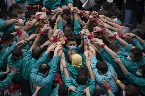 Участники берутся за руки, чтобы построить основу человеческой башни во время празднования Святой Евлалии в Барселоне. - Sputnik Азербайджан