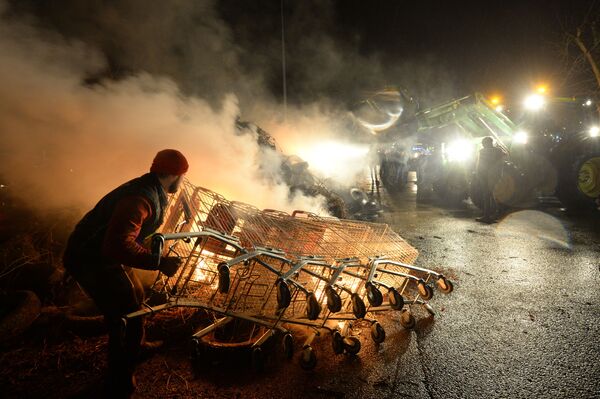 Фермеры сжигают сено возле супермаркета Ашан во время демонстрации в Ле-Мане, Франция. - Sputnik Азербайджан