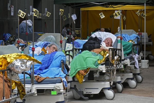 Пациенты в зоне временного содержания возле медицинского центра Каритас в Гонконге. - Sputnik Азербайджан