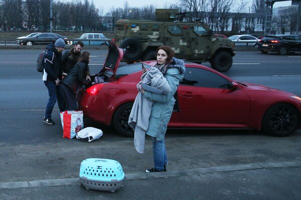 Киевляне грузят свои вещи в машину на одной из улиц города. - Sputnik Азербайджан