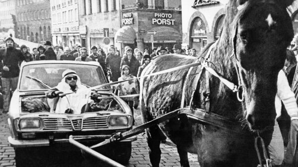Мужчина в костюме шейха держит поводья лошади, которая тащит автомобиль, переделанный в повозку, Нюрнберг, Германия, 25 ноября 1973 года - Sputnik Азербайджан