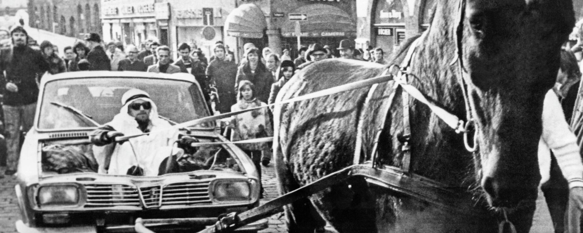 Мужчина в костюме шейха держит поводья лошади, которая тащит автомобиль, переделанный в повозку, Нюрнберг, Германия, 25 ноября 1973 года - Sputnik Азербайджан, 1920, 09.03.2022