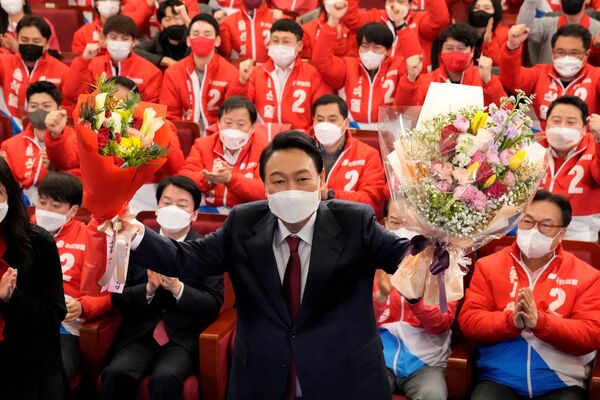 Новый президент Южной Кореи Юн Сок Ёль держит букеты в Сеуле. - Sputnik Азербайджан