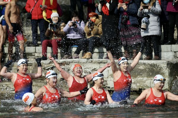 Группа китайских любительниц зимнего плавания во время заплыва в частично замерзшем озере во время празднования Международного женского дня в Шэньяне, Китай. - Sputnik Азербайджан
