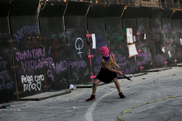 Женщина бросает мусор в забор во время акции протеста по случаю Международного женского дня в Мехико, Мексика. - Sputnik Азербайджан
