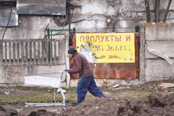 Местный житель тянут тележку в Мариуполе. - Sputnik Азербайджан