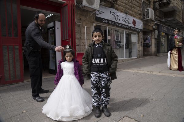 Ультраортодоксальный еврей поправляет корону на костюме своей дочери в Иерусалиме. - Sputnik Азербайджан