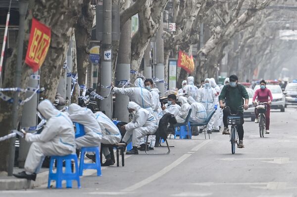 Рабочие в защитных костюмах во время локдауна в некоторых районах Шанхая. - Sputnik Азербайджан