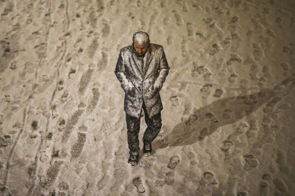 Мужчина на улице во время аномального снегопада в Стамбуле, Турция. - Sputnik Азербайджан