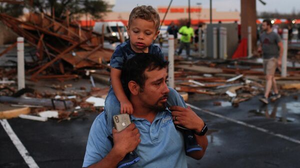 Мужчина с сыном около разрушенного в результате торнадо торгового центра в Раунд-Рок, штат Техас - Sputnik Азербайджан