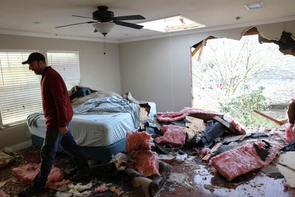 Мужчина в своем поврежденном в результате торнадо доме, Раунд-Рок, штат Техас. - Sputnik Азербайджан