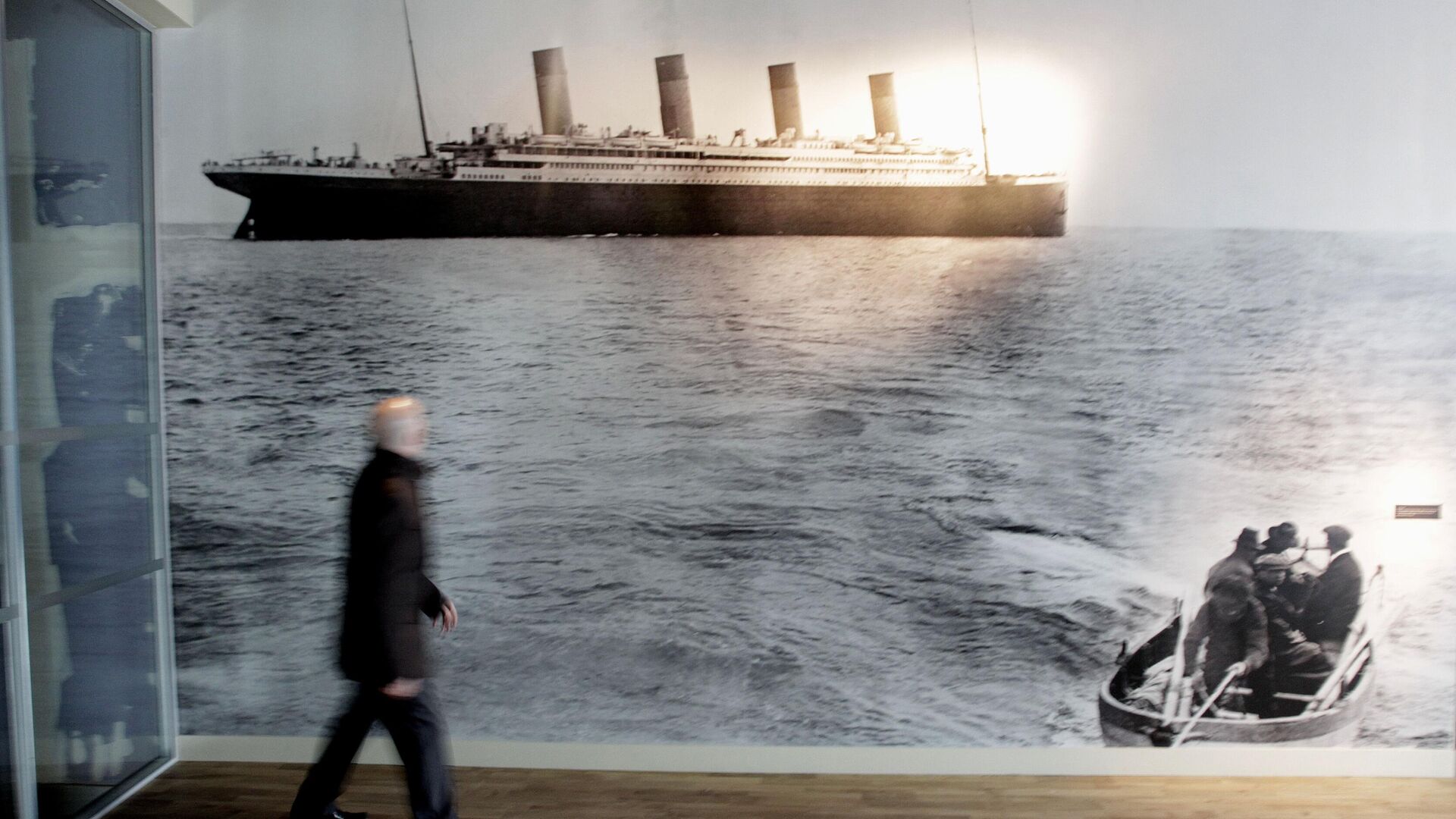 Мужчина проходит мимо последнего снимка «Титаника», сделанного у побережья Корка в Ирландии, фото из архива - Sputnik Азербайджан, 1920, 10.04.2022