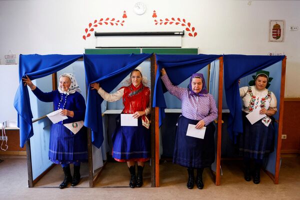 Венгерские женщины в традиционных костюмах на избирательном участке во время парламентских выборов в Верешедьхазе, Венгрия. - Sputnik Азербайджан