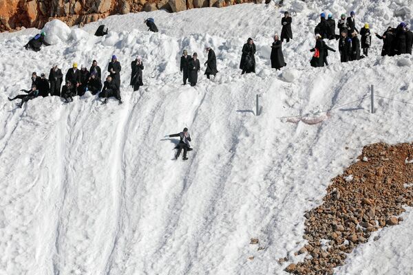 Ультраортодоксальные евреи играют катаются с горки на горнолыжном курорте Хермон на Голанских высотах. - Sputnik Азербайджан