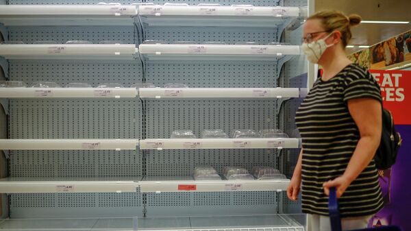 Покупатель проходит мимо пустой витрины с охлажденным мясом в конце прохода в супермаркете Sainsbury's в Уолтемстоу, восточный Лондон. - Sputnik Азербайджан