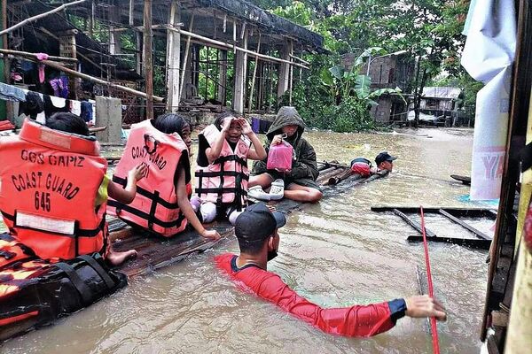 Спасатели эвакуируют жителей из затопленной деревни в Панитане, Филиппины. - Sputnik Азербайджан