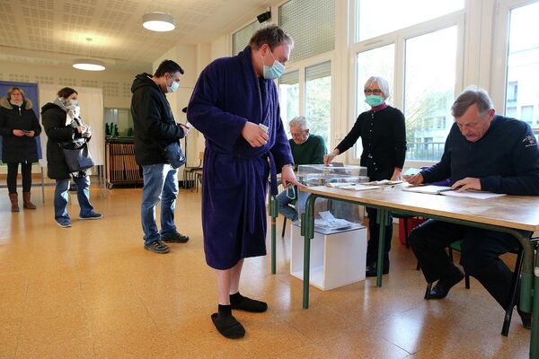 Избиратель в халате и тапочках прибывает на избирательный участок в Реймсе, Франция. - Sputnik Азербайджан