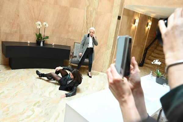 Протестующая рядом с Мари-Каролин Ле Пен после удаления из зала пресс-конференции Марин Ле Пен в Париже. - Sputnik Азербайджан