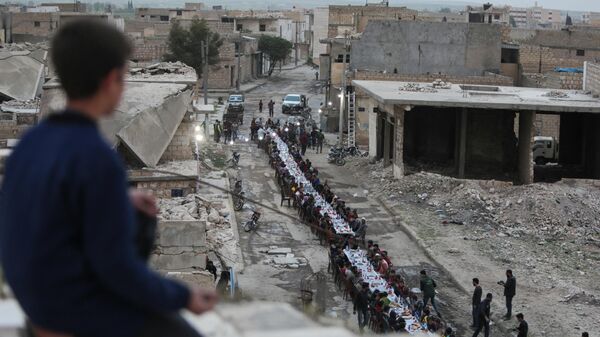 Сирийцы собираются за столом, чтобы прервать пост во время ифтара недалеко от пограничного города эль-Баб - Sputnik Азербайджан