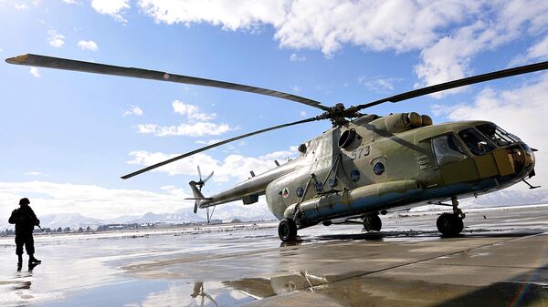 Солдат афганской армии идет перед вертолетом МИ-17 в военном аэропорту в Кабуле - Sputnik Азербайджан