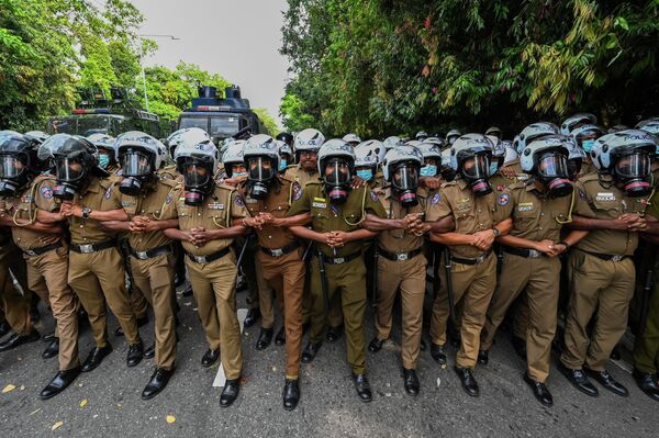 Полицейские стоят на страже во время демонстрации студентов возле здания парламента в Коломбо, Шри-Ланка. - Sputnik Азербайджан