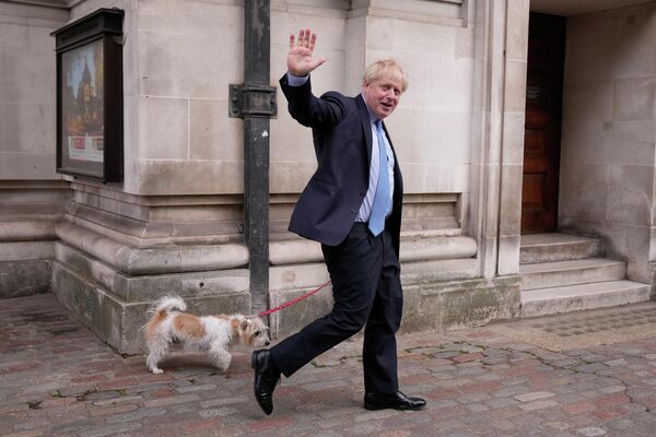 Премьер-министр Великобритании Борис Джонсон со своей собакой после голосования на избирательном участке в Лондоне. - Sputnik Азербайджан