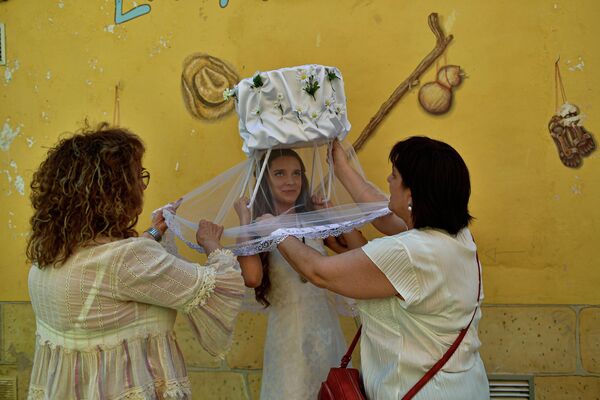 Их лица покрыты тюлем или марлей, а на головах они несут корзину с хлебами, на которых изображена фигура Санто-Доминго де ла Кальсада. - Sputnik Азербайджан