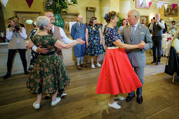 Британский принц Чарльз танцует с Бриджит Тиббс во время юбилейного чайного танца, Англия. - Sputnik Азербайджан