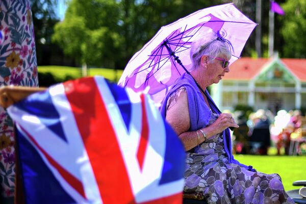 Гости наслаждаются прекрасной погодой на юбилейном пикнике в Бремаре, в центральной Шотландии, 5 июня 2022 года в рамках празднования платинового юбилея королевы Елизаветы II. - Sputnik Азербайджан